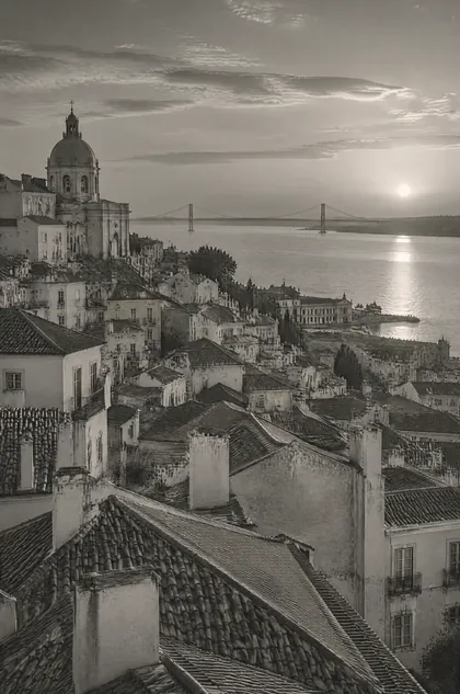 Lisbon’s rooftops stepping down to the Tagus at golden hour, in silver tones